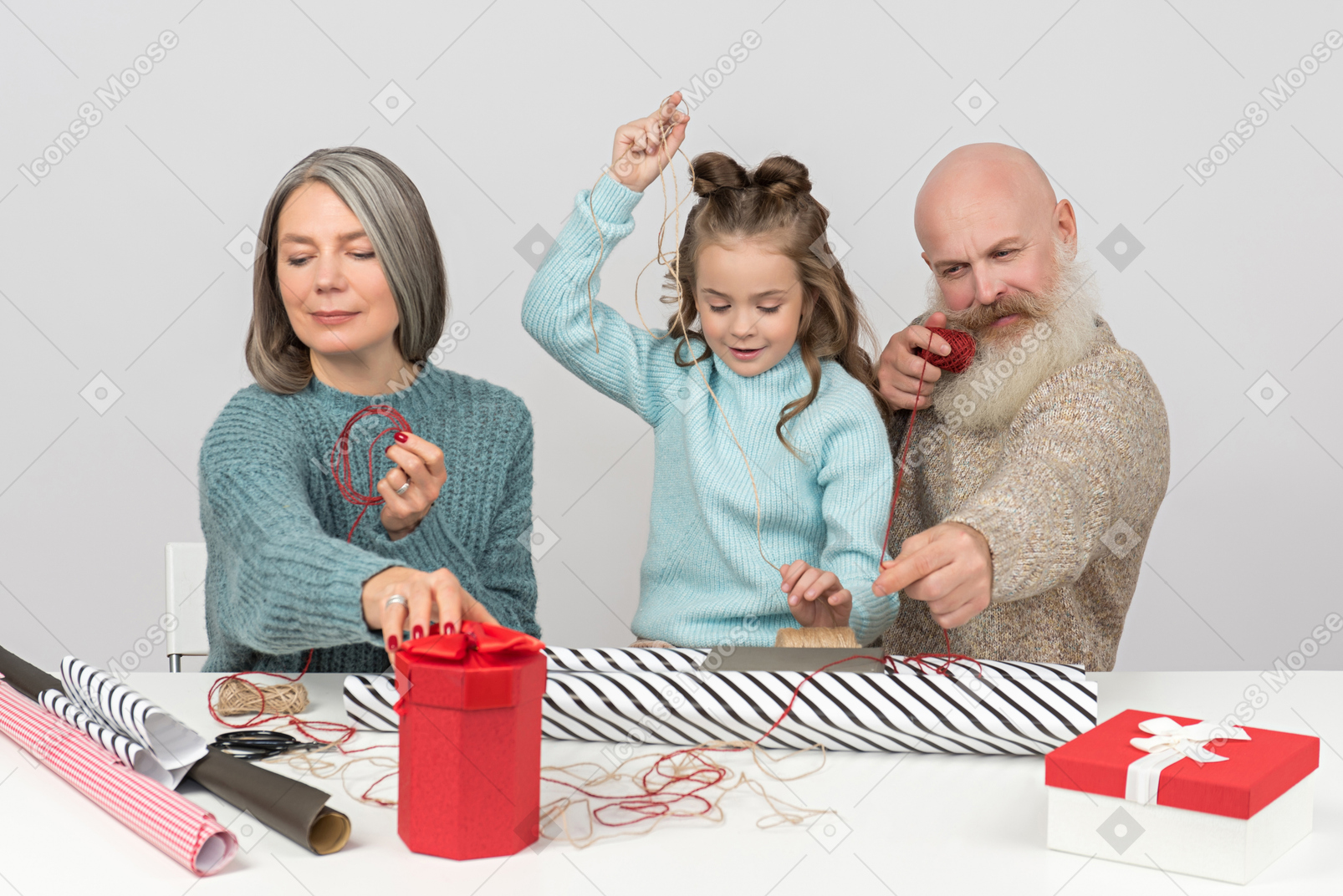 Grandparents and granddaughter wrapping gifts