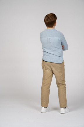 Back view of a boy posing with crossed arms