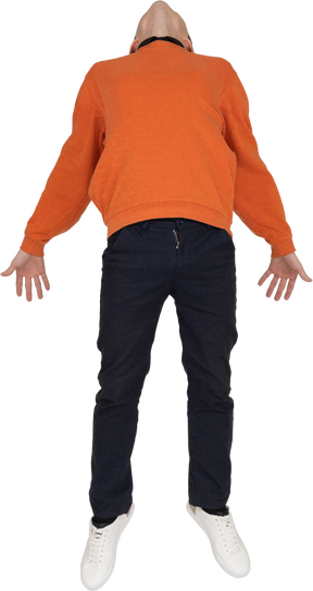 Молодой человек в оранжевой толстовке прыгает