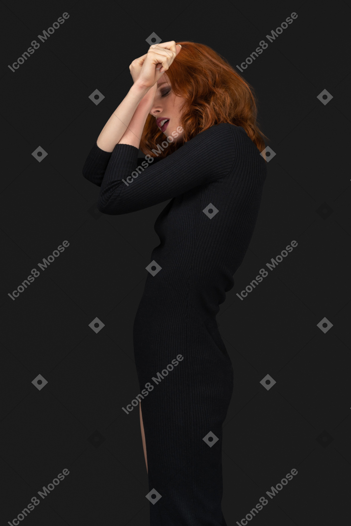 A side view of the sexy girl dressed in black and covering her face