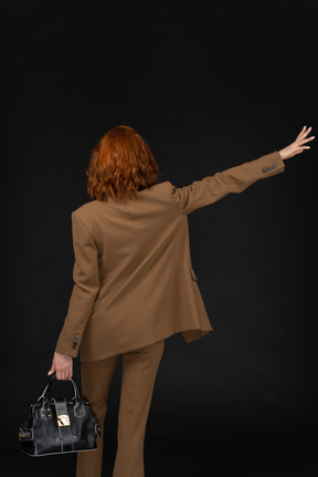 Back view of a businesswoman hailing a cab