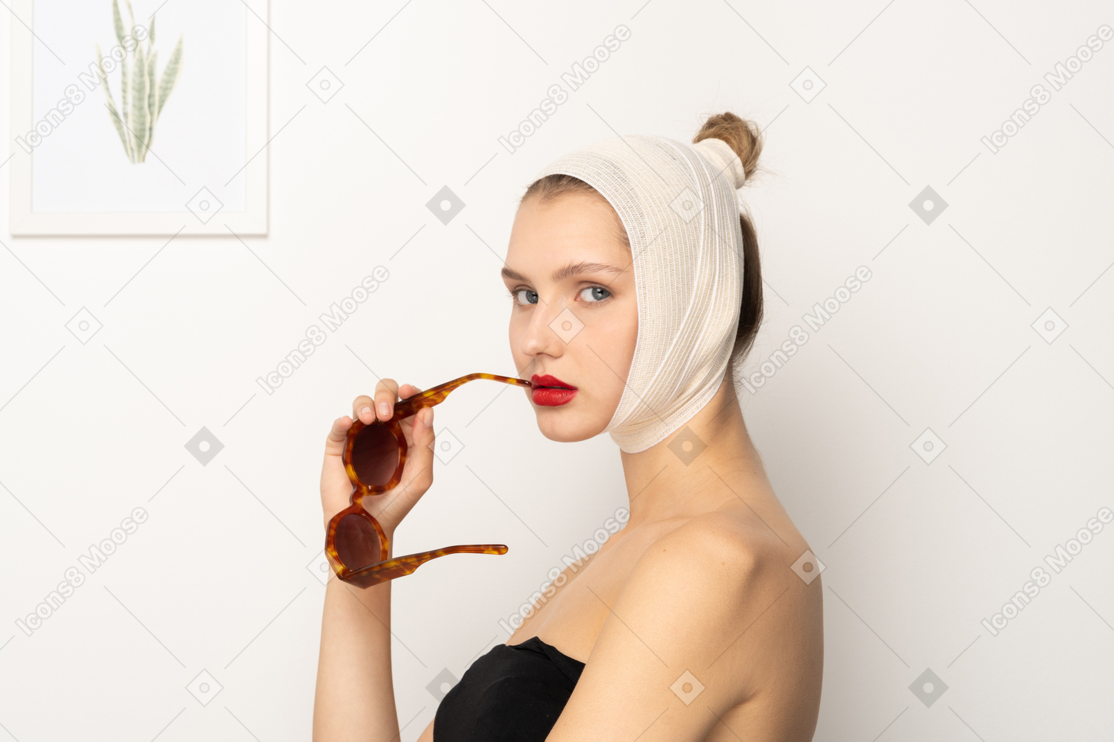 Side view of a woman with head bandage holding sunglasses