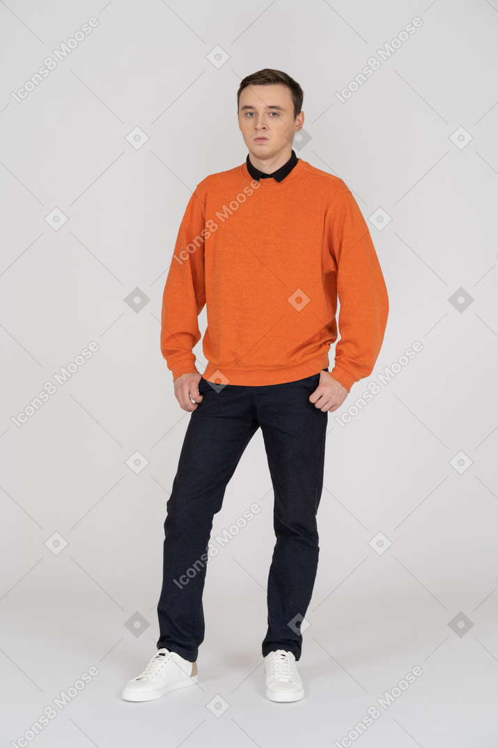 Young man in orange sweatshirt standing