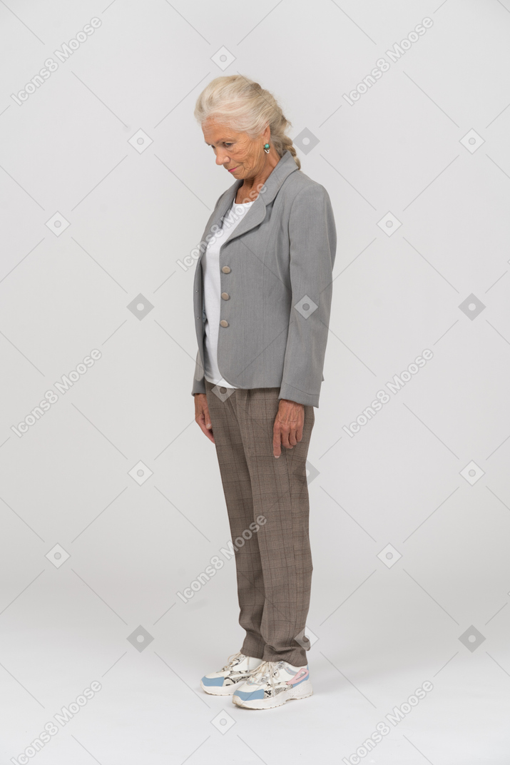 Side view of an old woman in suit looking down
