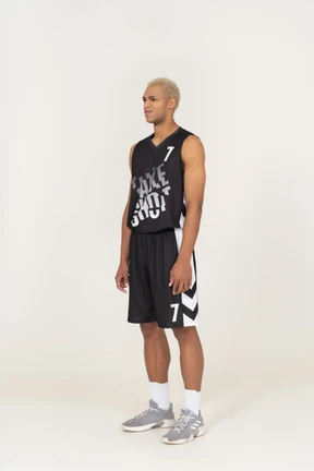 Three-quarter view of a displeased young male basketball player standing still