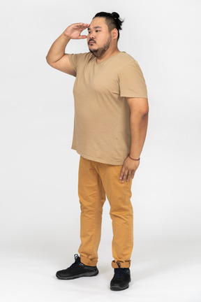 Young asian man saluting with hand