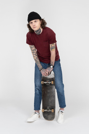 A teenager standing with his skateboard