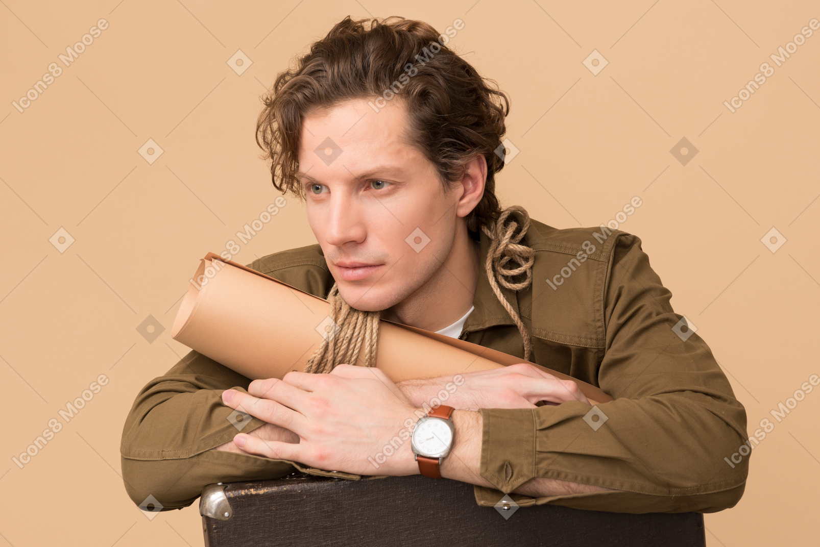 Handsome young traveller holding rolled map and old suitcase