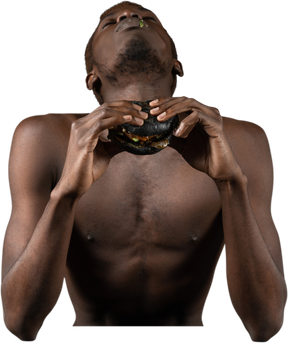 ハンバーガーを楽しんでいる若いアフロ男の正面図