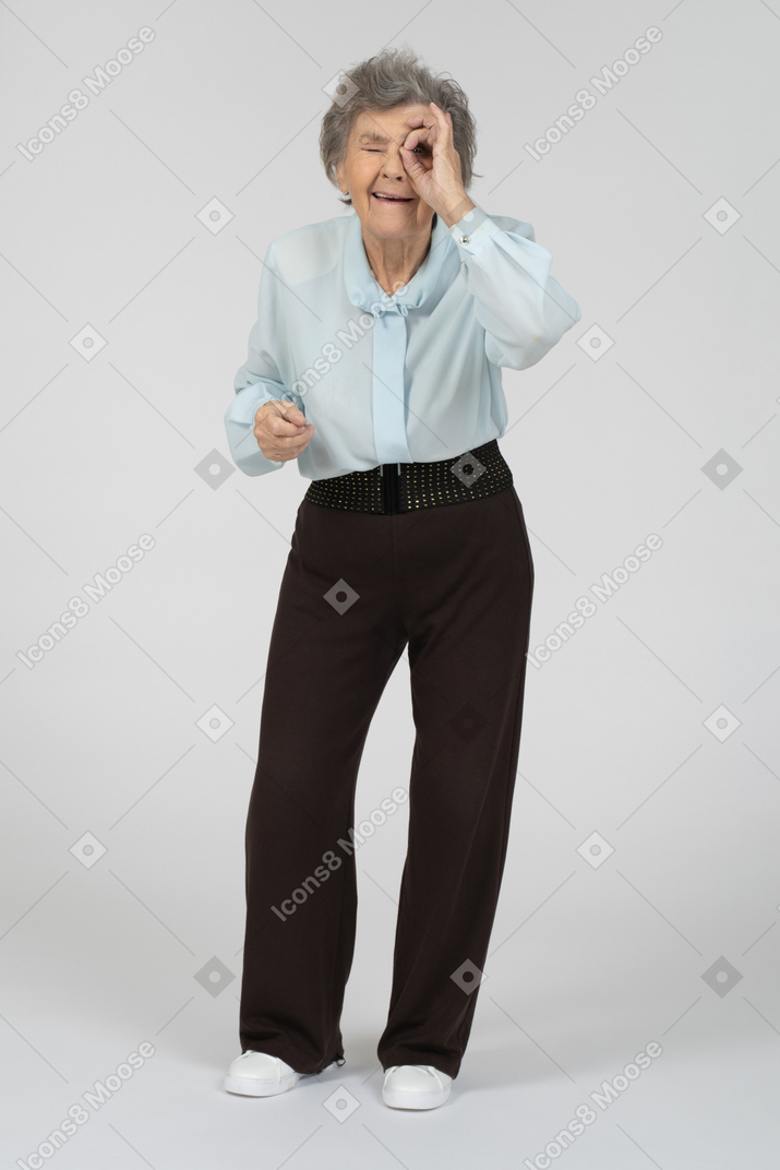 Anciana mirando a través de los dedos