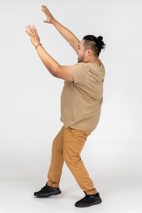 Asian man surrendering with his hands up in the air