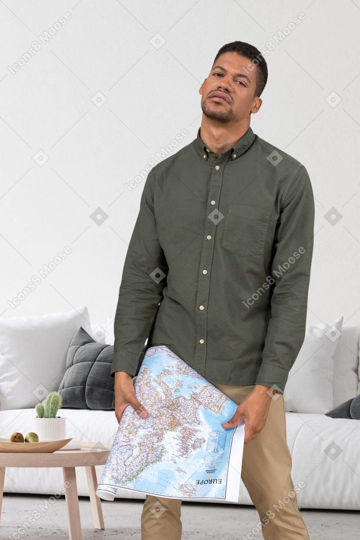 Frustrierter mann, der mit einer karte in seinem wohnzimmer steht