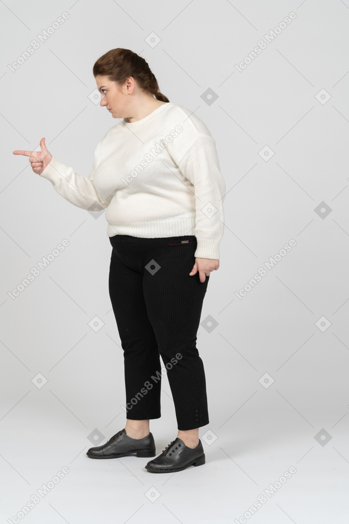 Vista lateral de uma mulher gorda apontando com um dedo