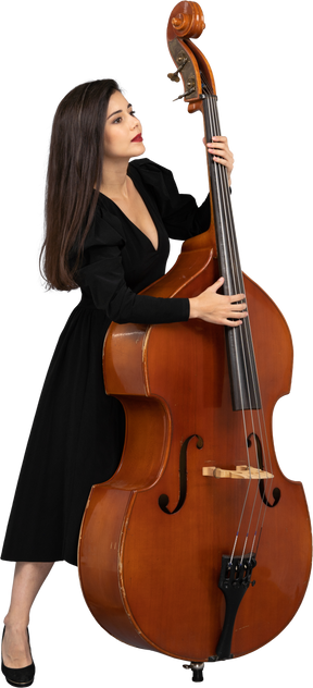 Full-length of a young lady in a black dress leaning on her double-bass