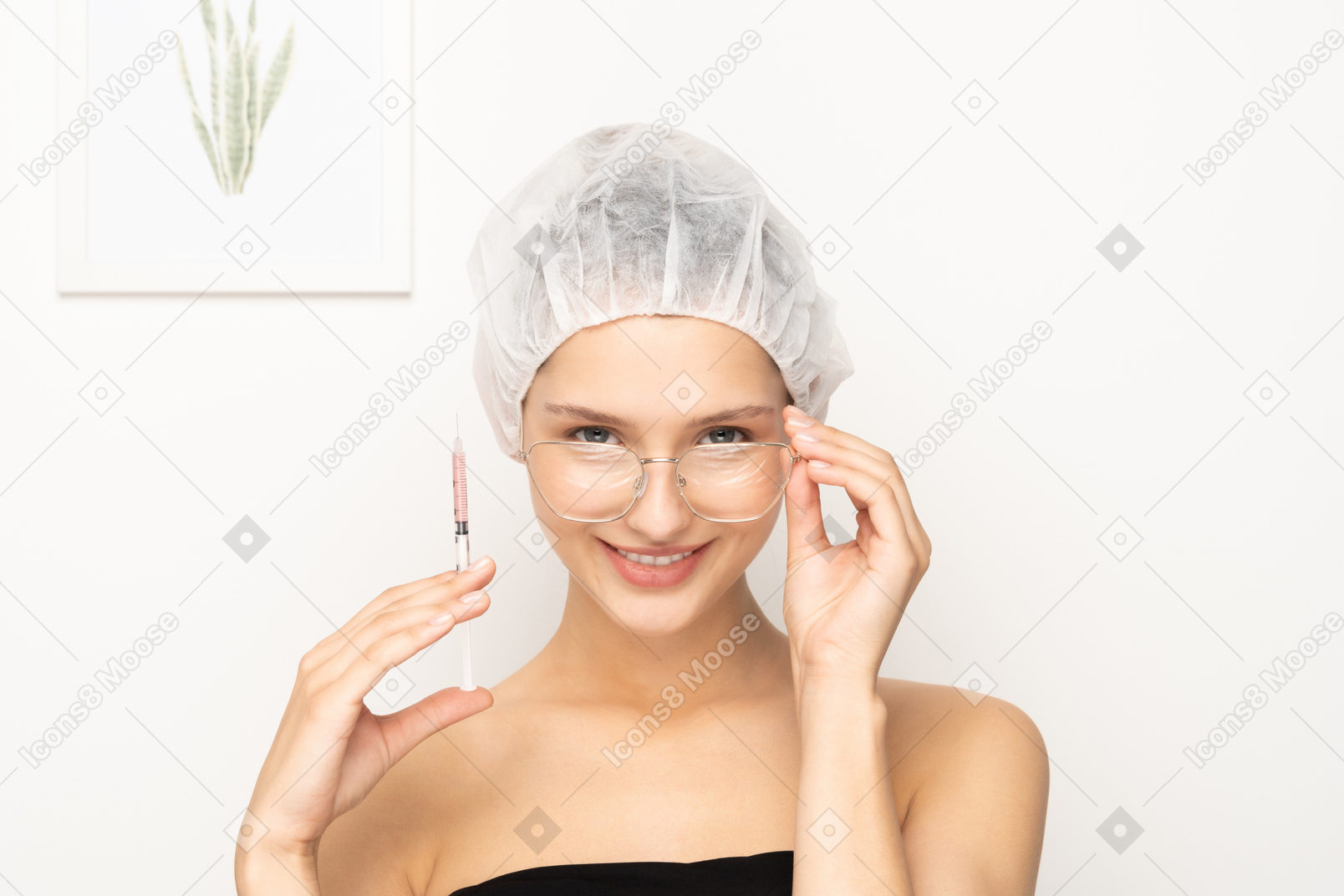 Молодая улыбающаяся женщина в очках, держащая шприц