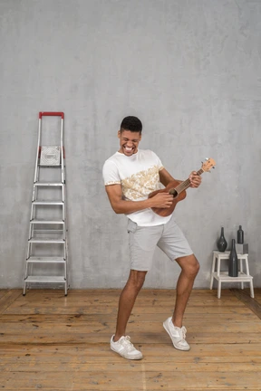 Vista de tres cuartos de un hombre tocando el ukelele