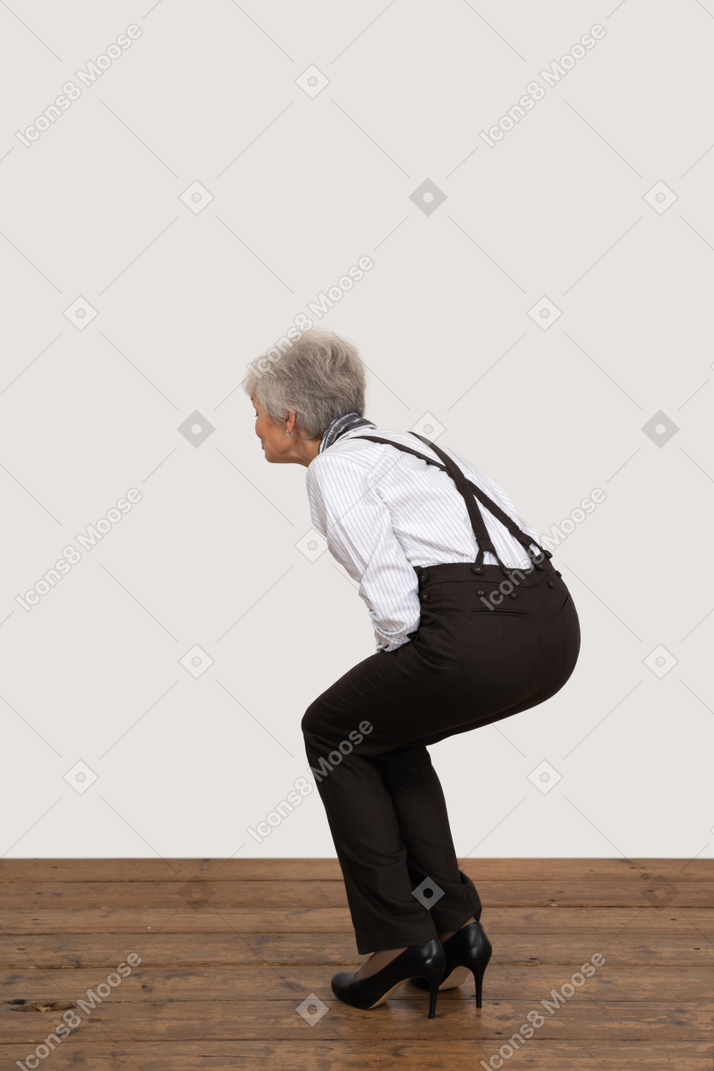 Side view of a squatting old lady