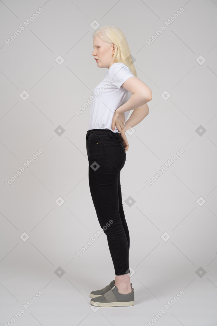 Vista lateral de una mujer con dolor de espalda