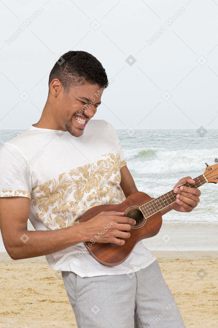 Person plays guitar on the beach