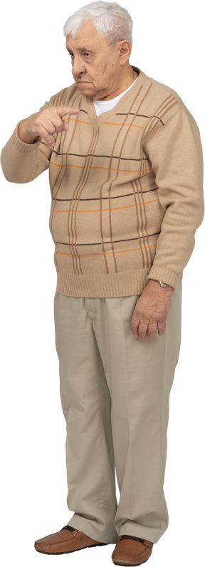 Vista frontale di un uomo anziano in abiti casual che punta con il dito