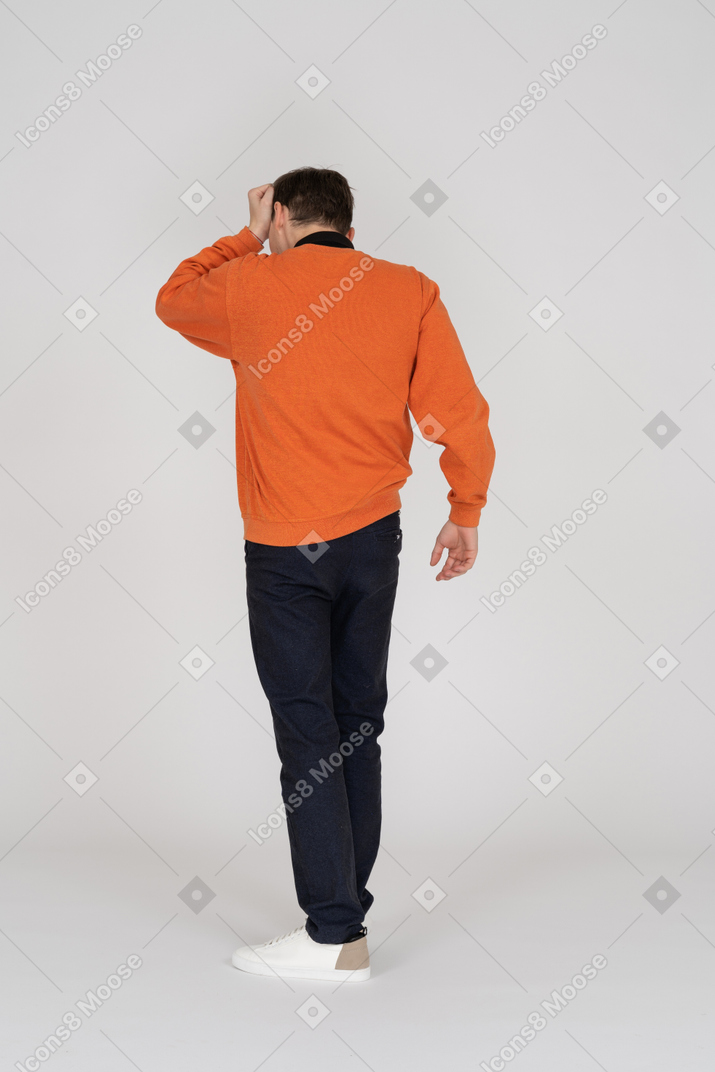 Young man in orange sweatshirt standing