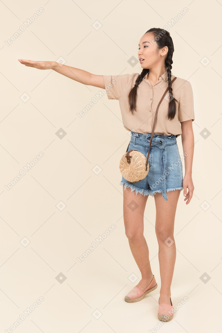 Young woman in casual clothes raising her hand