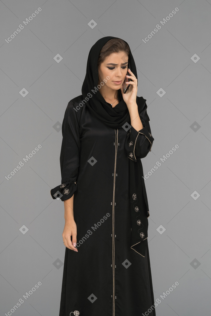 Mujer musulmana cubierta hablando por teléfono