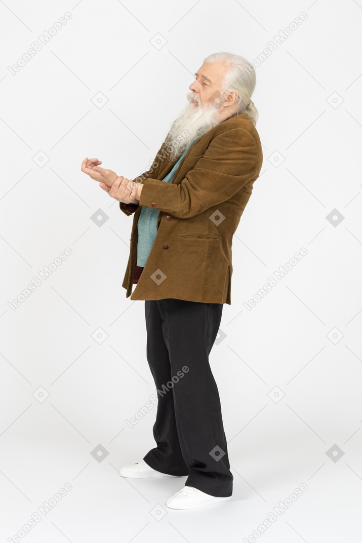 Elderly man holding his arm, looking to be in pain