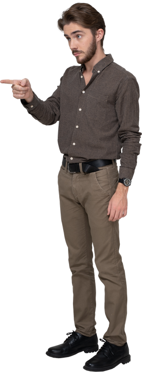 Dreiviertelansicht eines jungen mannes in bürokleidung, der mit dem finger nach vorne zeigt