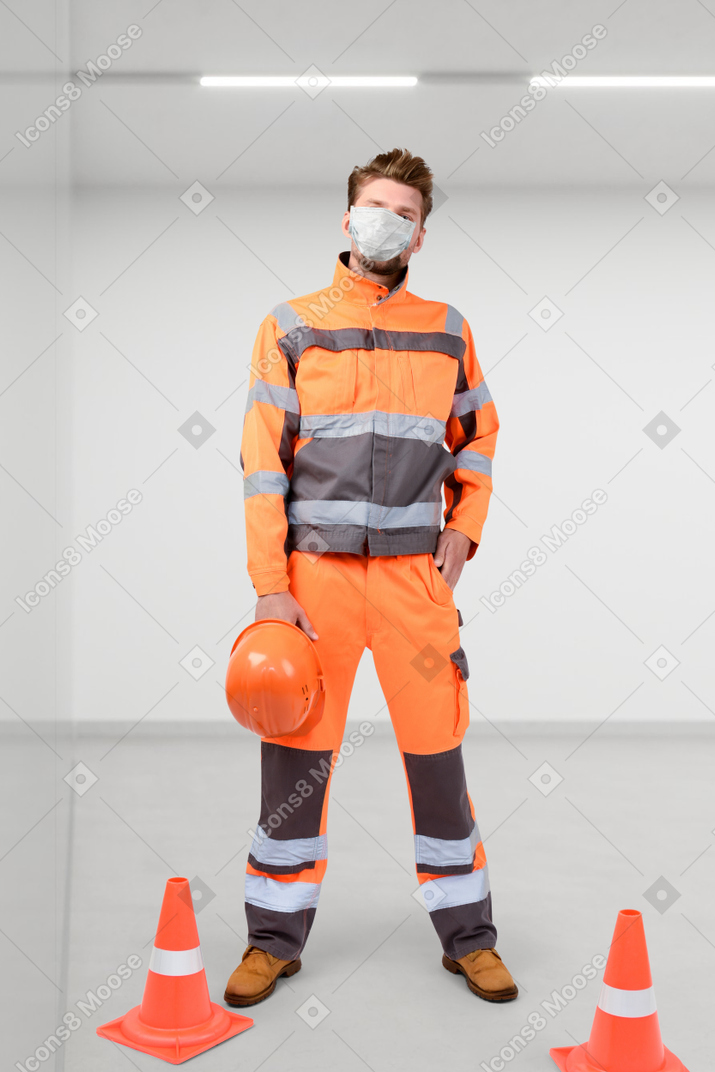 A man wearing an orange safety suit and a mask