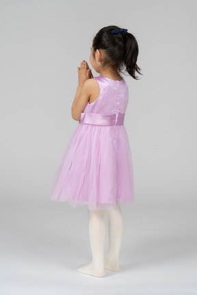그녀의 손을 접힌 핑크 드레스에 소녀