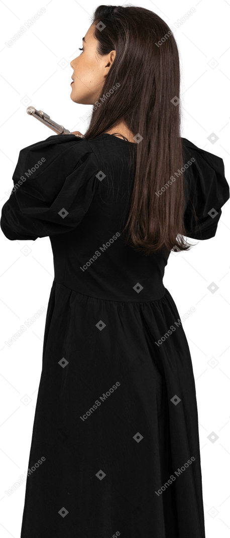 Vista traseira de uma jovem de vestido preto segurando uma flauta