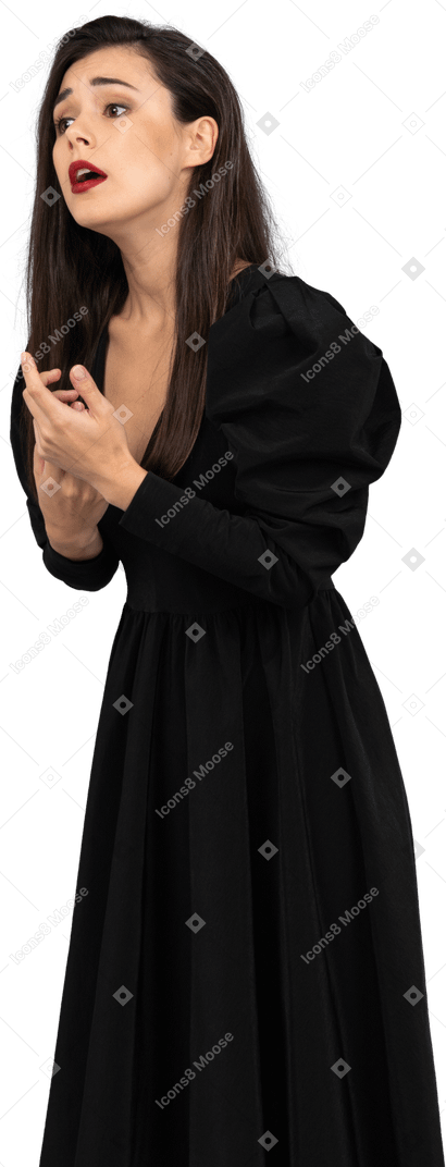Three-quarter view of a worried gesticulating young woman in black dress
