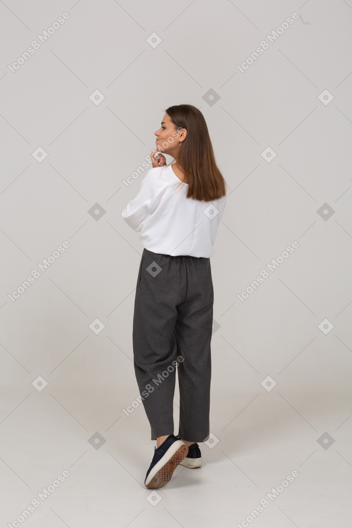 Vista posteriore di tre quarti di una giovane donna premurosa in abiti da ufficio che tocca il mento