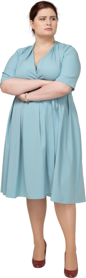 Vista frontale di una donna in abito blu in posa con le braccia incrociate