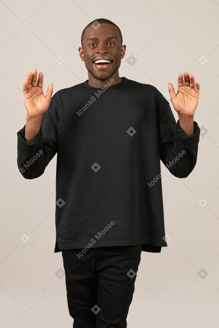 Excited young man with raised hands