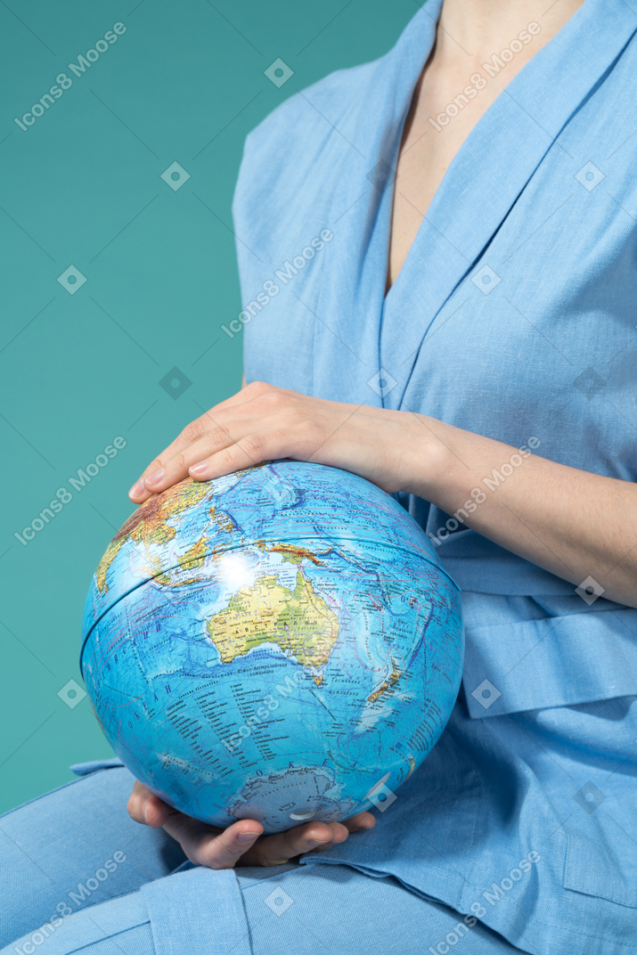 Une femme tenant le globe terrestre