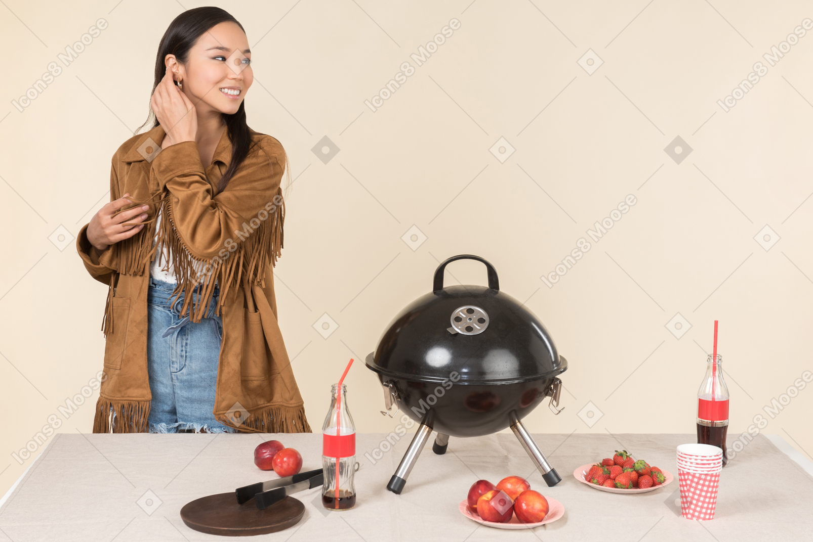 Giovane donna asiatica in piedi vicino alla griglia chiusa sul tavolo