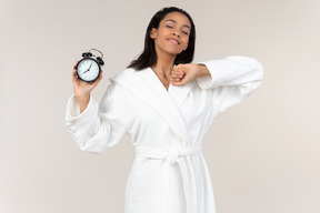 Black woman in white bathrobe going about her morning routine