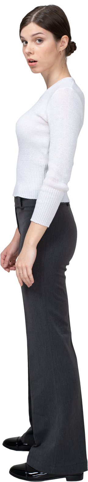 Side view of a surprised young woman in office clothing turning away