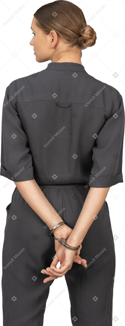 Vista posteriore di una giovane donna in tuta che indossa le manette