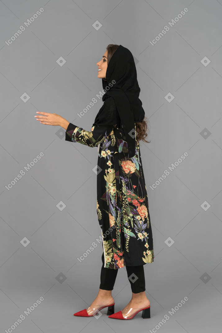 Mujer árabe contenta extendiendo la mano para un apretón de manos