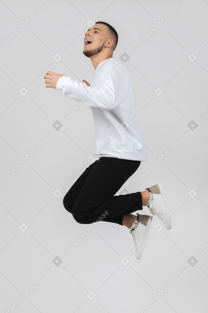 Счастливый молодой человек прыгает