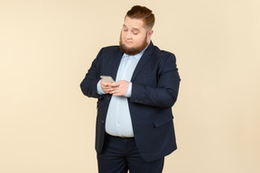 Young overweight office worker checking phone