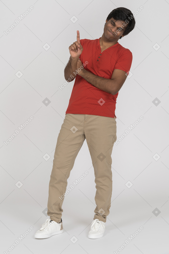 Young man grimacing and pointing up