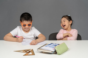 Mädchen lacht über ihren bruder mit sonnenbrille