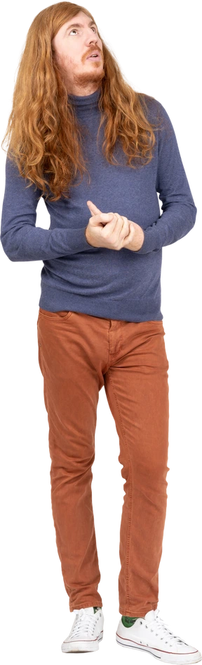 Front view of a thoughtful young man in casual clothes looking up