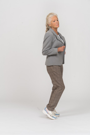 一位身穿灰色西装跑步的老妇人的侧视图