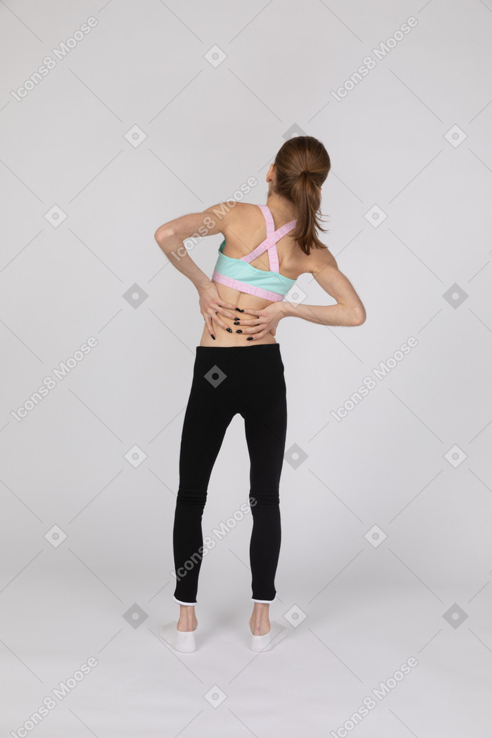 Вид сзади девочки-подростка, страдающей от болей в спине