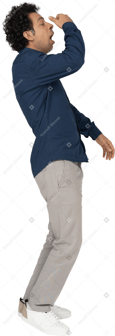 Side view of a man in casual clothes sneezing